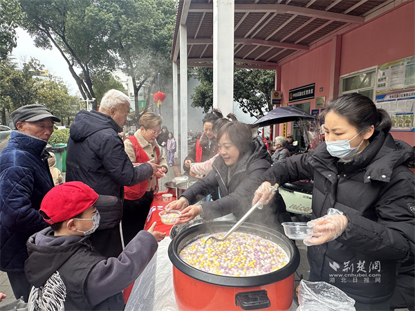 志愿者們將軟糯香甜的元宵遞到居民手里.jpg